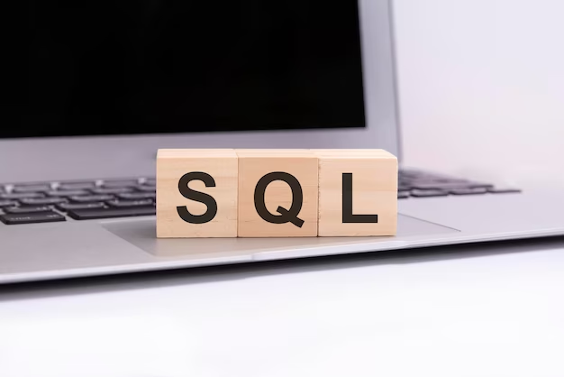 Wooden cubes with letters SQL on a silver laptop keyboard