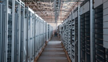 A row of metal racks in a warehouse specifically designed to house physical dedicated servers (VDS).