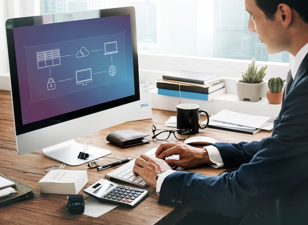 A man in a suit works at a computer