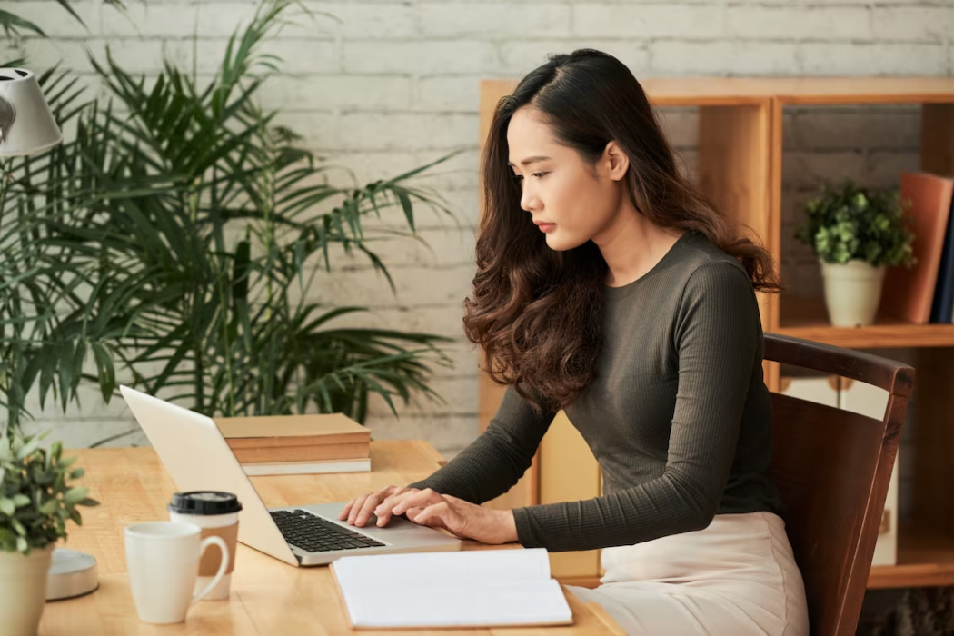 Woman with long sleeves using a laptop on a table